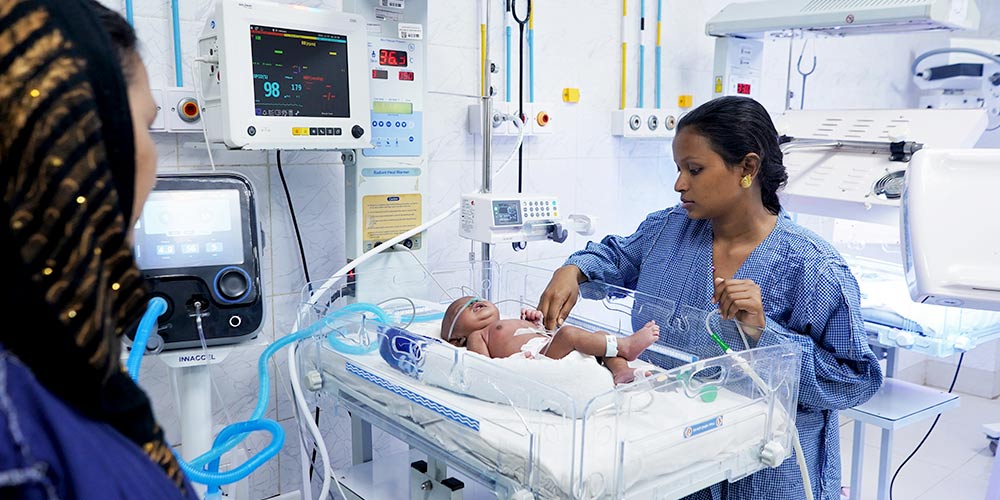 Image: Nazeera Begum looking on at her child